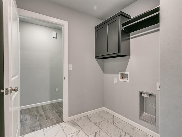 washroom featuring cabinet space, baseboards, washer hookup, and marble finish floor