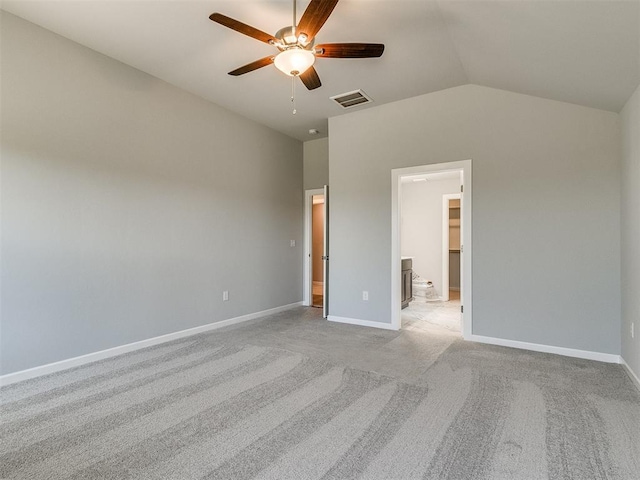 unfurnished bedroom with lofted ceiling, light colored carpet, visible vents, and baseboards