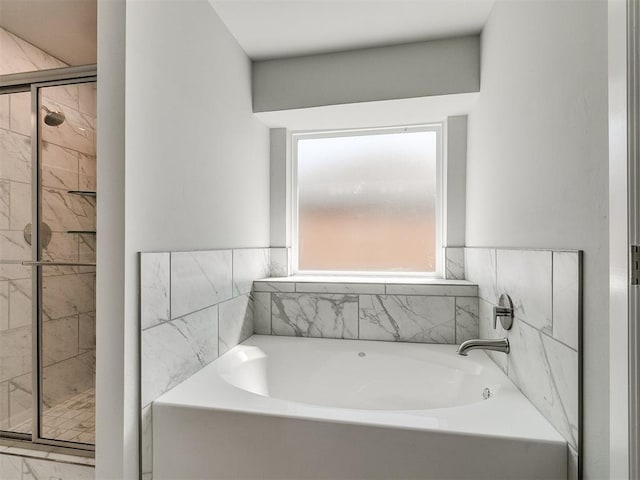 bathroom featuring a stall shower and a bath