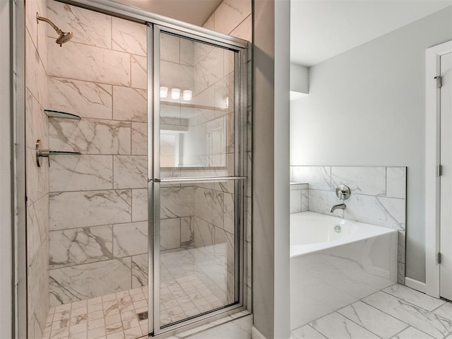 bathroom with marble finish floor, a shower stall, and a bath