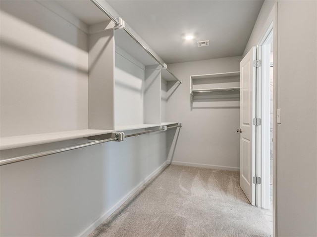 spacious closet featuring visible vents and light colored carpet
