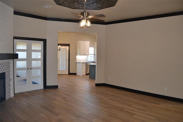 1525 NW 17th Pl, Newcastle, OK 73065 - unfurnished living room featuring visible vents, wood finished floors, baseboards, ceiling fan, and french doors