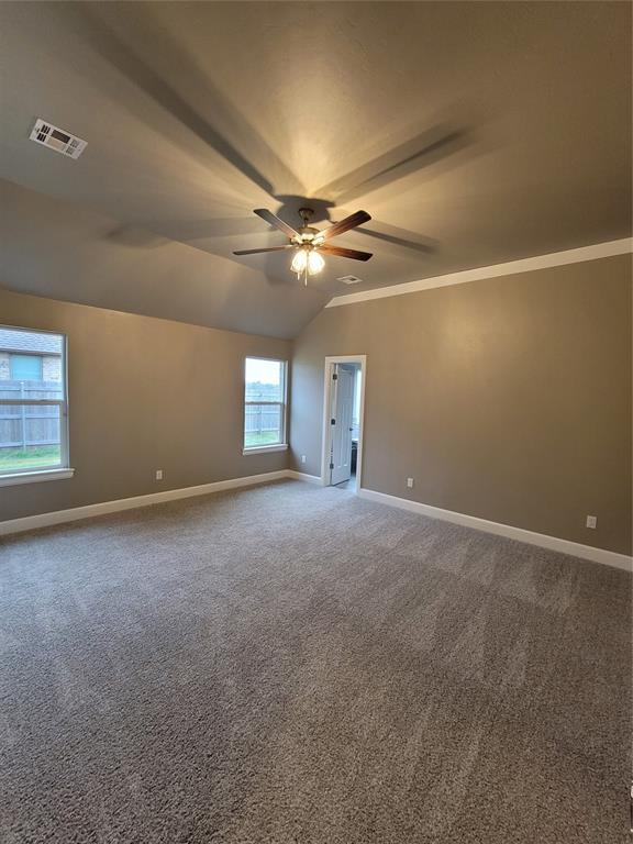 1525 NW 17th Pl, Newcastle, OK 73065 - unfurnished room with a ceiling fan, baseboards, visible vents, and vaulted ceiling