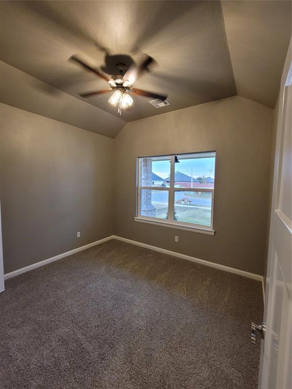 1525 NW 17th Pl, Newcastle, OK 73065 - empty room featuring baseboards, a ceiling fan, dark carpet, and lofted ceiling