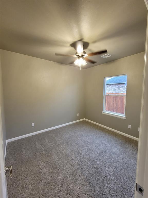 1525 NW 17th Pl, Newcastle, OK 73065 - carpeted empty room with a ceiling fan, baseboards, and visible vents
