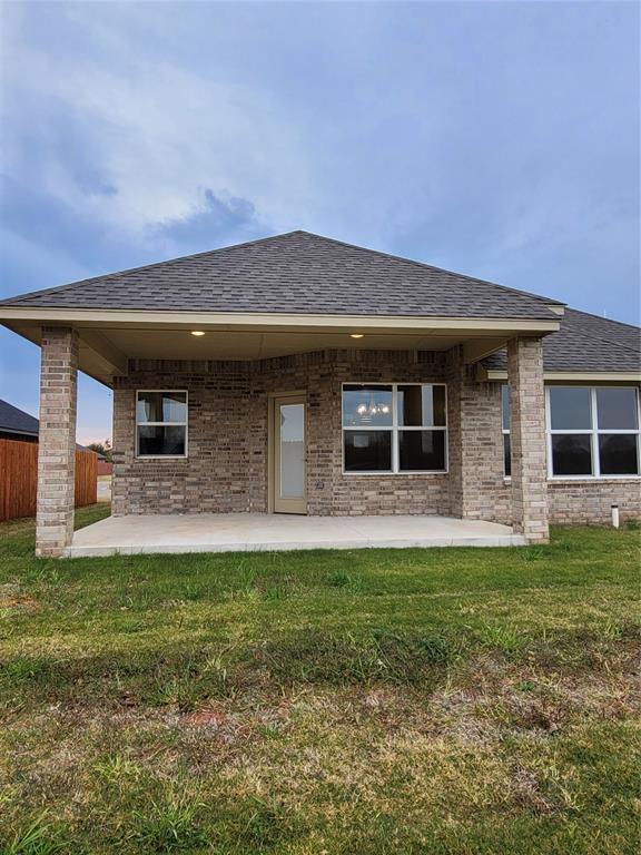 1525 NW 17th Pl, Newcastle, OK 73065 - rear view of house featuring a patio, a lawn, and brick siding