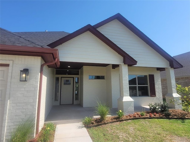 1525 NW 17th Pl, Newcastle, OK 73065 - property entrance featuring a yard, brick siding, and roof with shingles
