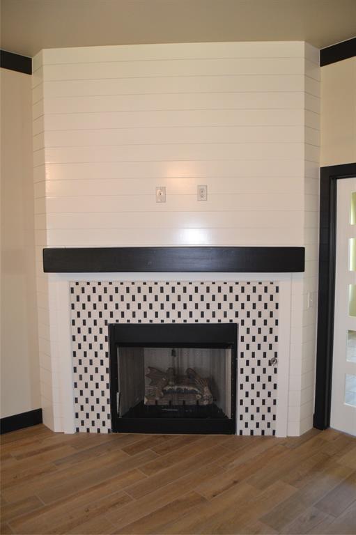 1525 NW 17th Pl, Newcastle, OK 73065 - room details with a tiled fireplace and wood finished floors