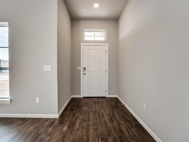 doorway featuring dark wood-style floors and baseboards