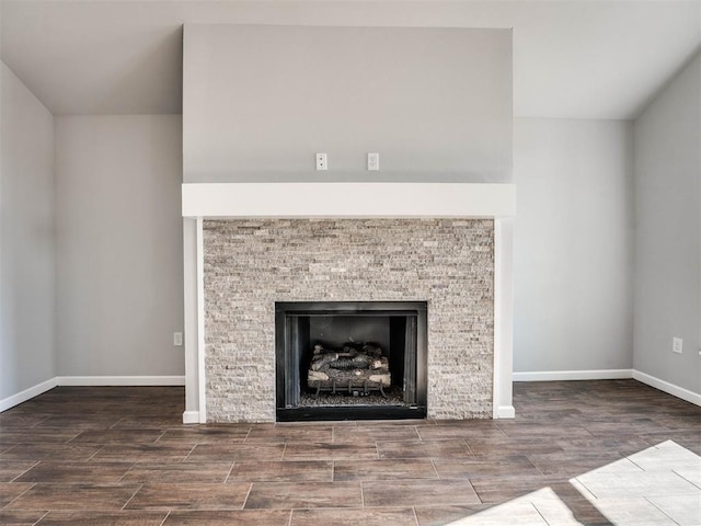 details featuring wood finish floors, a fireplace, and baseboards