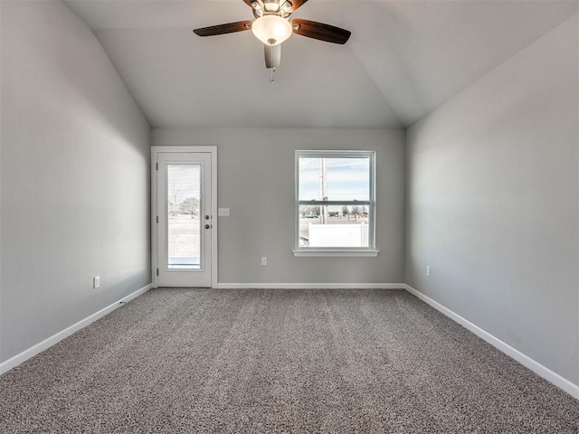 empty room with lofted ceiling, carpet, baseboards, and a ceiling fan