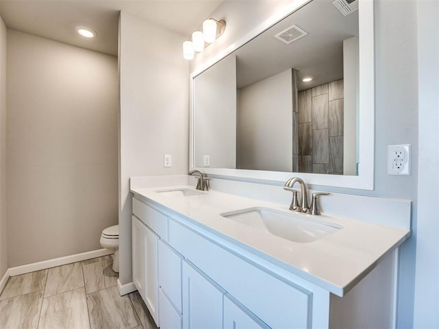 bathroom with double vanity, visible vents, and a sink