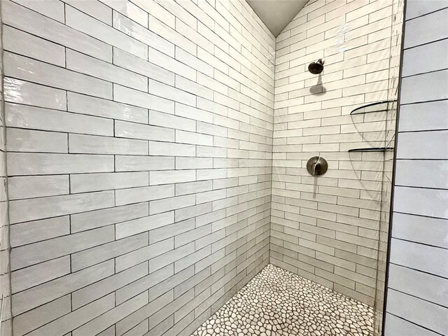 full bath with vaulted ceiling and tiled shower