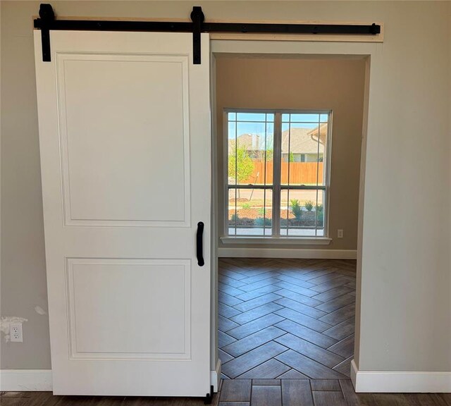 entryway with a barn door and baseboards