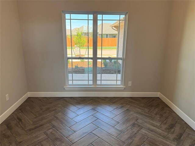spare room featuring baseboards and plenty of natural light