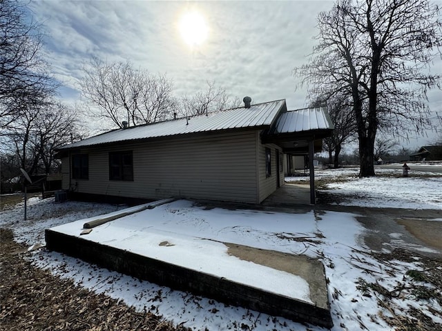 exterior space with central AC unit and metal roof