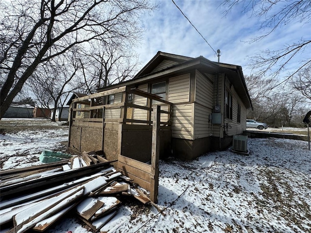 snow covered property featuring cooling unit