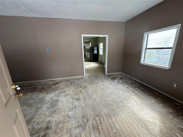 unfurnished room featuring hardwood / wood-style flooring and baseboards
