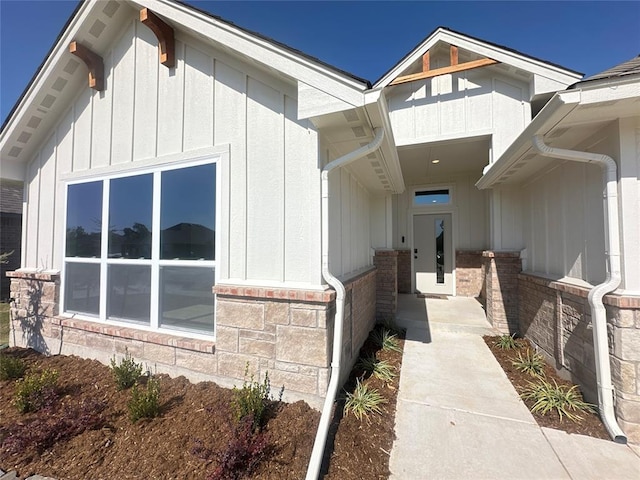 view of property exterior featuring brick siding, board and batten siding, and stone siding