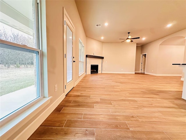 unfurnished living room featuring visible vents, baseboards, recessed lighting, a brick fireplace, and light wood-type flooring