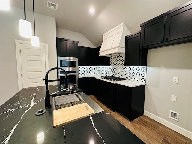 kitchen with tasteful backsplash, visible vents, stainless steel appliances, and dark cabinetry