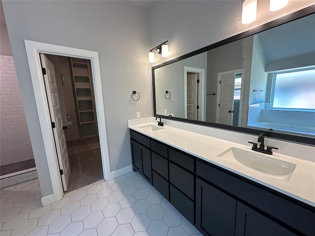 bathroom with a tile shower, double vanity, a garden tub, and a sink