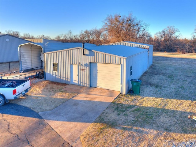 exterior space with concrete driveway and an outbuilding