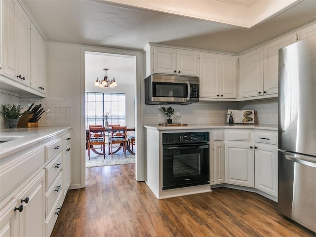 kitchen with white cabinets, dark wood finished floors, stainless steel appliances, and light countertops