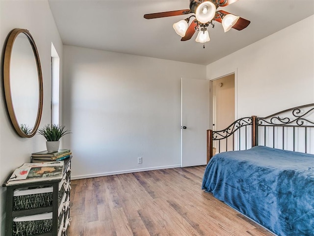 bedroom featuring ceiling fan, wood finished floors, and baseboards