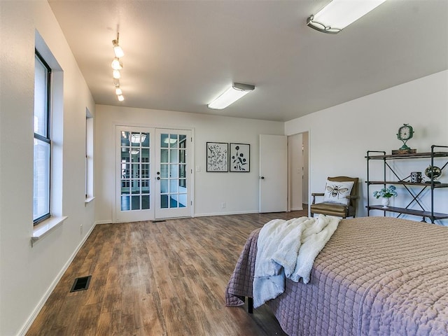 bedroom featuring french doors, multiple windows, wood finished floors, and visible vents