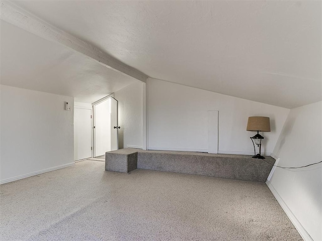 additional living space featuring lofted ceiling with beams, baseboards, and speckled floor