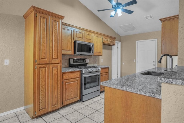 kitchen featuring light tile patterned floors, lofted ceiling, visible vents, appliances with stainless steel finishes, and a sink