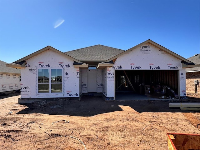 property under construction featuring a garage and roof with shingles