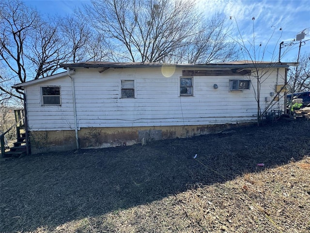 view of side of property with an AC wall unit