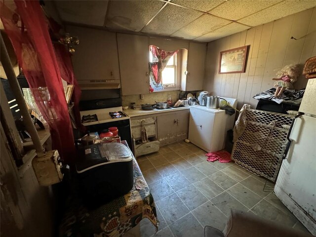 laundry room featuring washer / clothes dryer, wooden walls, and laundry area