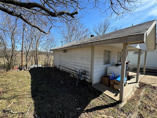 view of side of home with roof with shingles