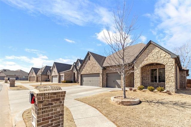 view of front of house with concrete driveway, stone siding, a residential view, an attached garage, and brick siding