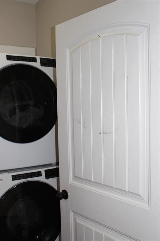 washroom featuring stacked washer and dryer and laundry area