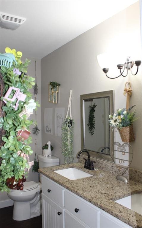 bathroom with visible vents, vanity, and toilet