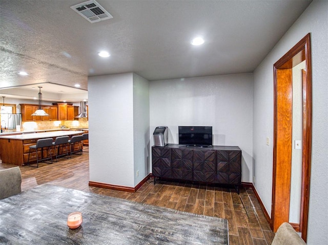 living room featuring wood tiled floor, visible vents, baseboards, and recessed lighting