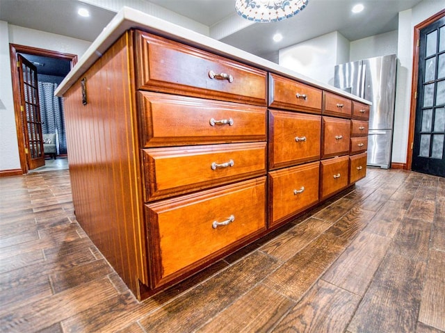 room details with baseboards, wood finished floors, and freestanding refrigerator