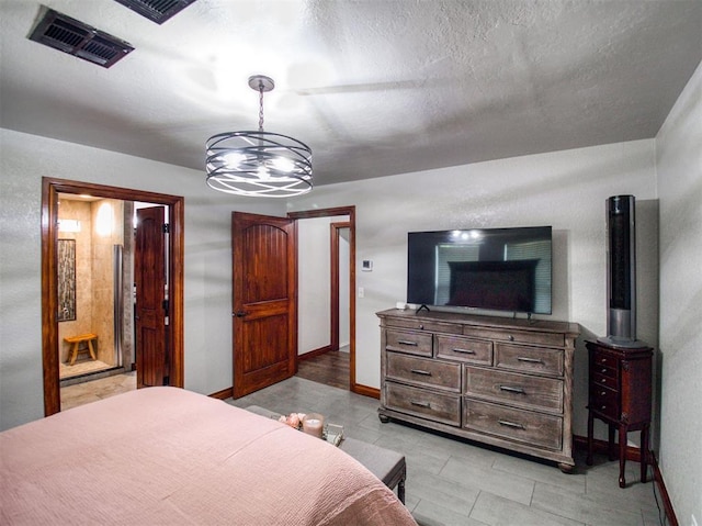 bedroom featuring visible vents, ensuite bath, baseboards, and a textured ceiling