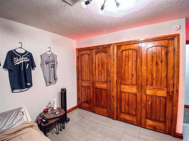 interior space with a textured ceiling and baseboards