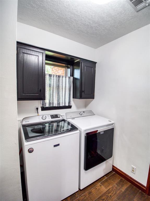 laundry area with cabinet space, baseboards, visible vents, dark wood-style flooring, and independent washer and dryer