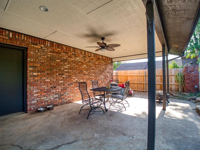 view of patio with ceiling fan, outdoor dining area, and fence