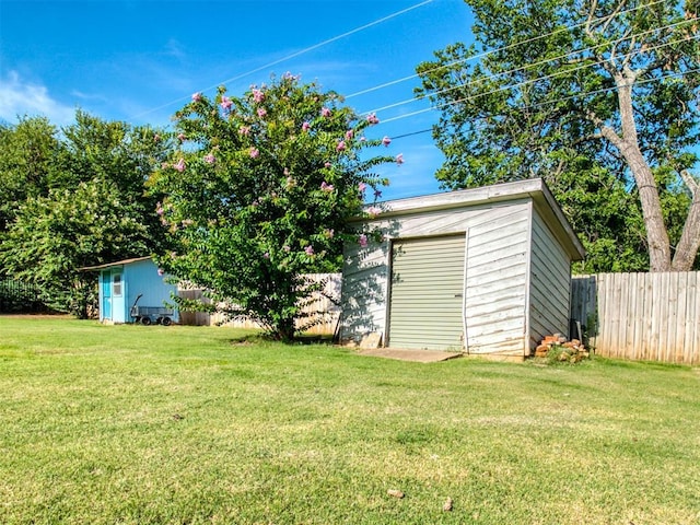 view of yard featuring an outdoor structure and fence