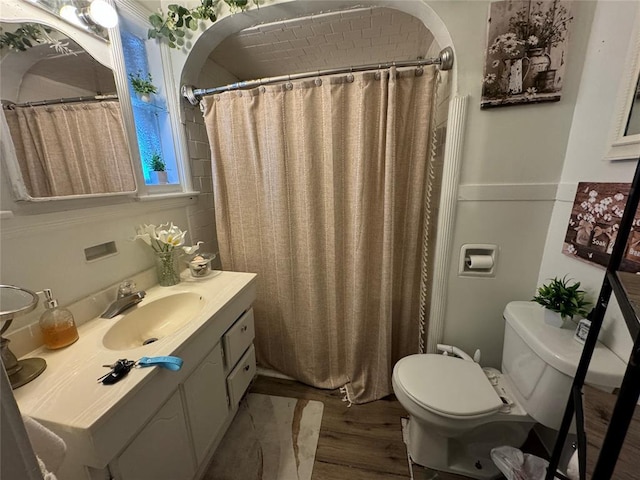 full bathroom with toilet, a shower with curtain, wood finished floors, and vanity