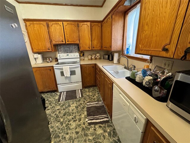 kitchen featuring appliances with stainless steel finishes, brown cabinets, a sink, and light countertops