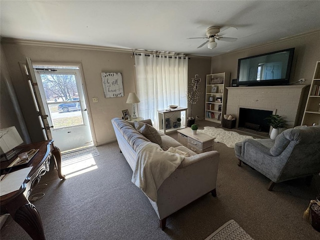 carpeted living room with ceiling fan, a fireplace, and crown molding