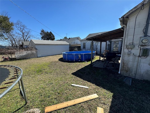 view of yard with a trampoline, a fenced in pool, a patio area, and fence